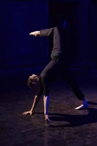gillian upside down with hands on the ground and leg over her head