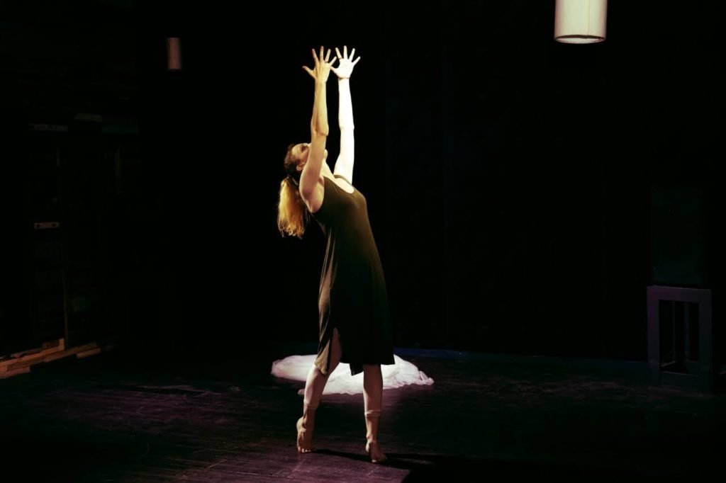 Gillian in fourth position with arms outstretched to the ceiling