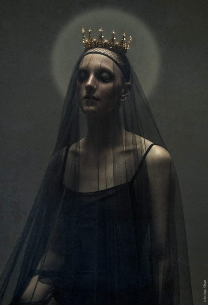 Gillian in a black leotard with a black net over her and a halo