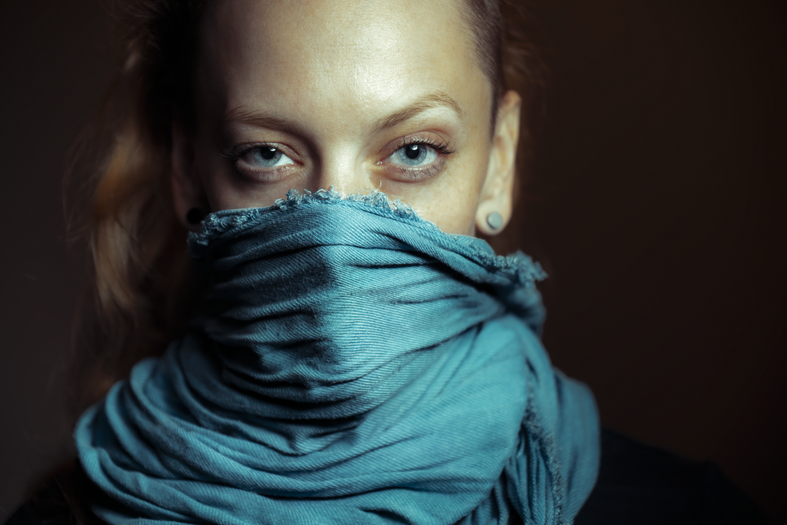 Gillian wearing a blue scarf to cover her nose and mouth and looking directly into the camera