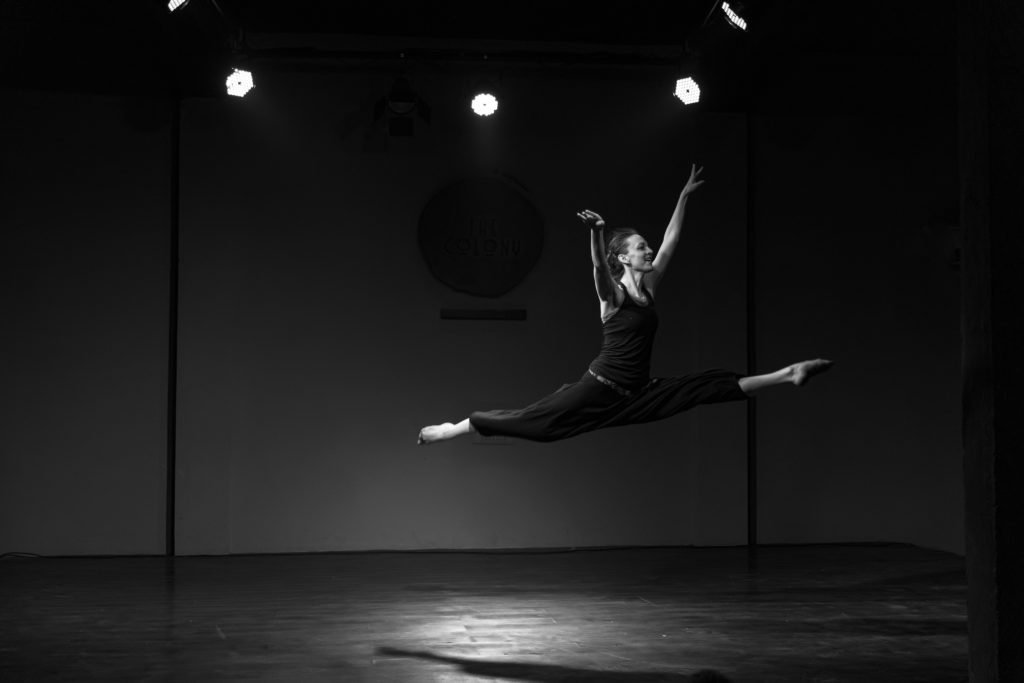 GIllian leaping in the splits on a stage