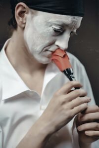closeup of GIllian as Pierrot holding a paper flower
