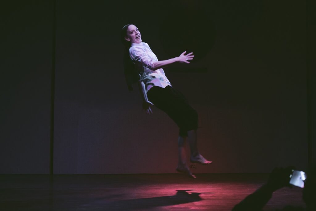 Gillian performing in mid aiir smiling at the camera