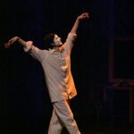 The sad clown Pierrot facing to the right with arms raised and a rose in one hand