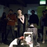 Gillian in a gallery space in a wig cap