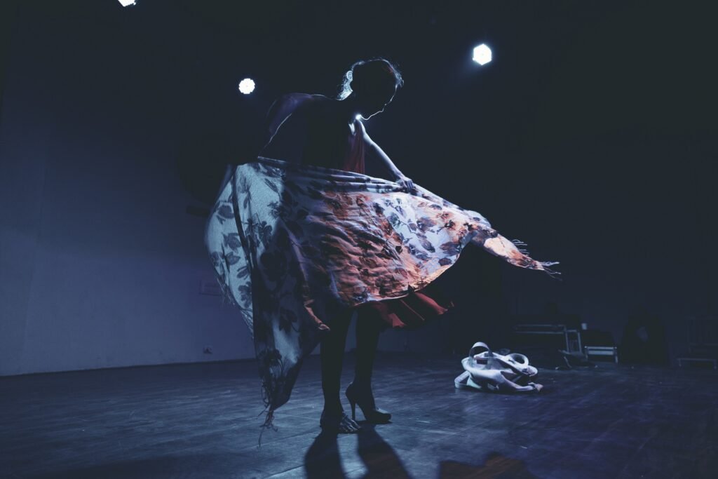 gillian performing in silhouette with a flowered scarf flowing in front of her