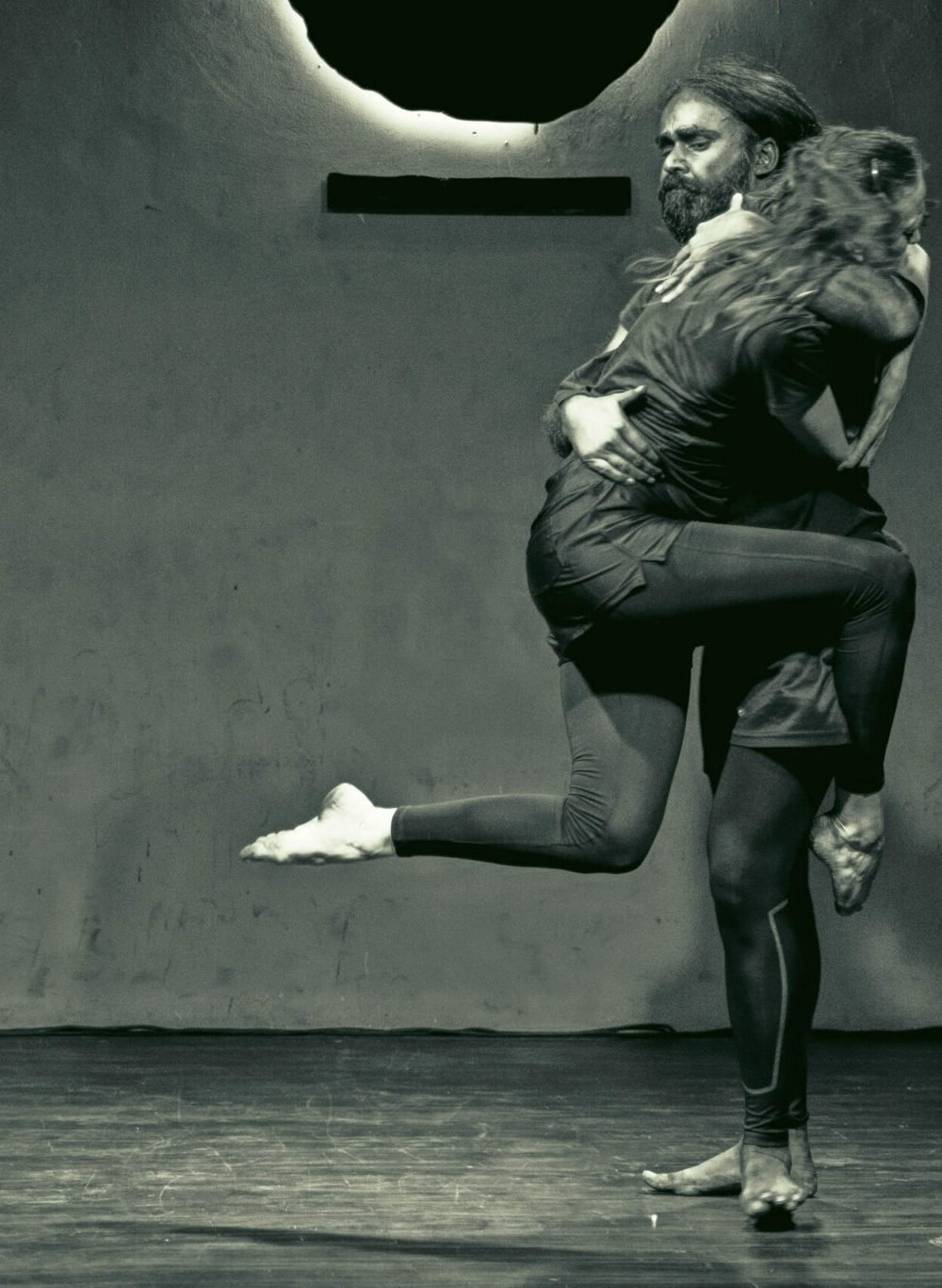 a dancer leaping into another dancer's arms in black and white